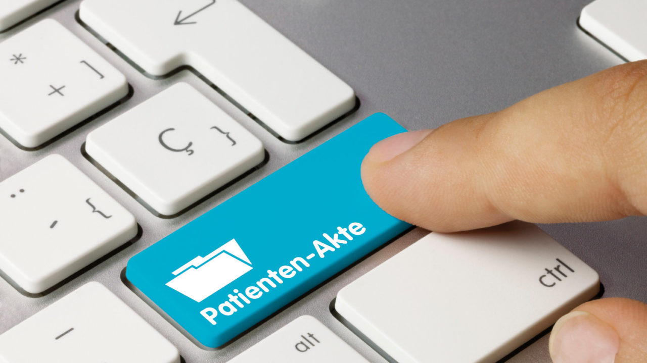 Computertastatur bei der auf der rechten Shift-Taste ein Ordner abgebildet ist, unter dem "Patienten-Akte" steht.